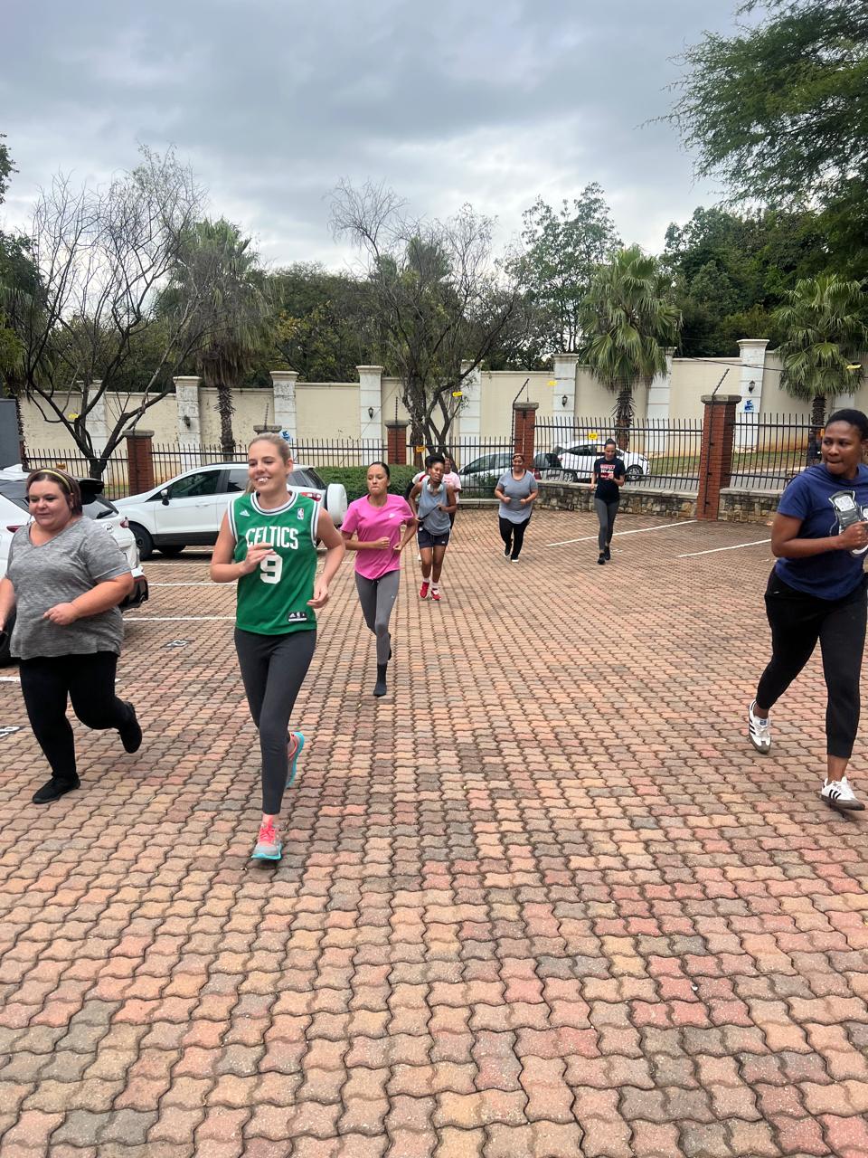 Employees running together outdoors during a corporate fitness session